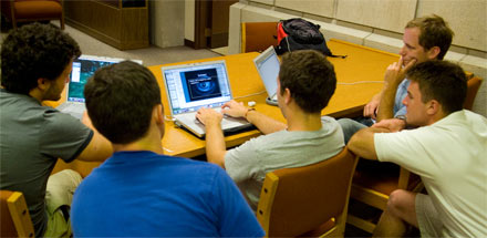 A group of students working on a laptop.