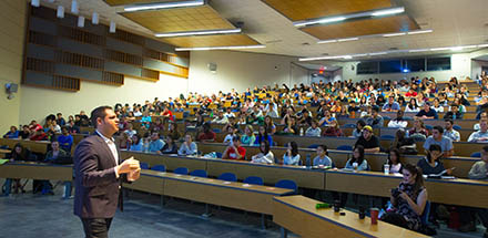 Professor speaking in front of large class.