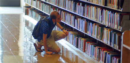 Student searching for a book in the library.
